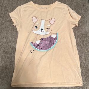 This is a kids shirt with a dog holding a watermelon